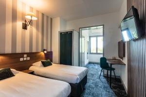 ロカマドゥールにあるルレ アマドーリアンのベッド2台とデスクが備わるホテルルームです。