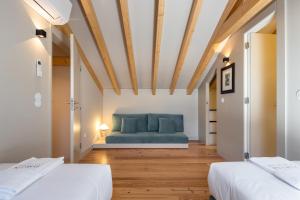 a bedroom with two beds and a blue couch at ORM Portas Santa Catarina Apartments in Porto