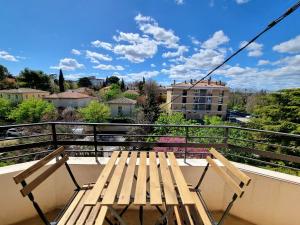 a table and chairs on a balcony with a view at Appartement spacieux de standing - parking gratuit in Aix-en-Provence
