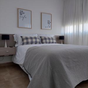 een slaapkamer met een bed en twee foto's aan de muur bij Rentarte in Pilar