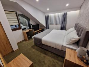 a hotel room with a large bed and a desk at Lakeside in Zlatibor
