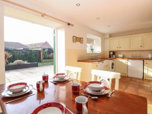 a kitchen and dining room with a wooden table at The Old Cartshed in Lowestoft