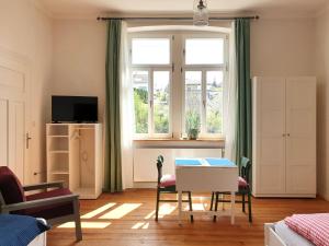 uma sala de estar com uma mesa e uma janela em Bahnhof Grombach em Bad Rappenau