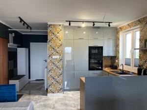 a kitchen with white cabinets and a counter top at Apartament Anna in Sandomierz