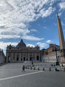 a person walking in front of a large building at Dream Holiday Home in Rome