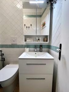 bagno con lavandino bianco e servizi igienici di Divina Casa Vacanze Donna Silvana a Sperlonga