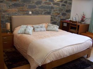 een slaapkamer met een bed met 2 kussens erop bij Hotel Santa Apolonia in Bragança