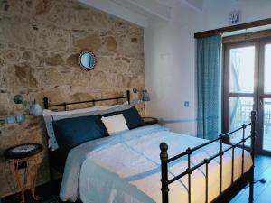 1 dormitorio con cama y pared de piedra en Stou Kir Yianni, en Omodos