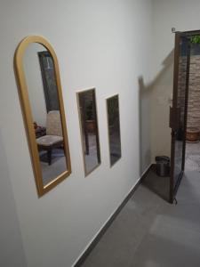 um quarto com três espelhos e uma cadeira na parede em DIMASHQ em Penonomé