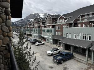 a parking lot with cars parked in front of buildings at Luxury Two Queen Beds Condo - Grande Rockies Resort Indoor Parking Pool Hot tub GYM in Canmore