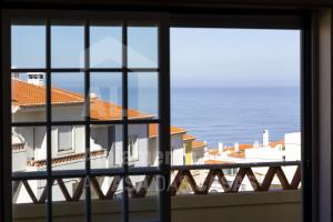 uma vista para o oceano a partir de uma janela em Villa BelaVista by ACasaDasCasas na Ericeira