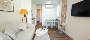 a living room with a white couch and a table at Chez Adriana Studio VUE MER avec Piscine in Grimaud