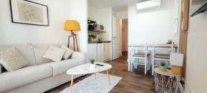 a living room with a white couch and a table at Chez Adriana Studio VUE MER avec Piscine in Grimaud