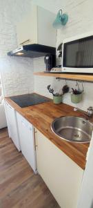 a kitchen with a sink and a microwave at Chez Adriana Studio VUE MER avec Piscine in Grimaud +1 photo