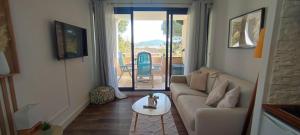 ein Wohnzimmer mit einem Sofa und einem Tisch in der Unterkunft Chez Adriana Studio VUE MER avec Piscine in Grimaud