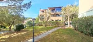 a street light in the grass in front of a building at Chez Adriana Studio VUE MER avec Piscine in Grimaud