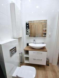 uma casa de banho branca com um lavatório e um WC em Apartamenty ASLux - Noclegi Energylandia Zator em Zator