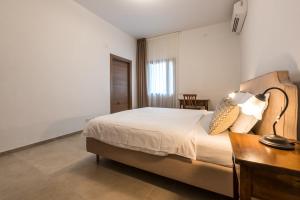 - une chambre avec un lit, un bureau et une lampe dans l'établissement Agriturismo La Collina degli Olivi, à Certaldo