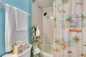 a bathroom with a toilet and a shower with a shower curtain at Walk to Lakes! Tropical Escape in Mount Dora in Mount Dora +20 photos