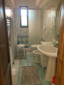 ein Badezimmer mit einem Waschbecken, einem WC und einem Waschbecken in der Unterkunft Tuscany Location in Marta