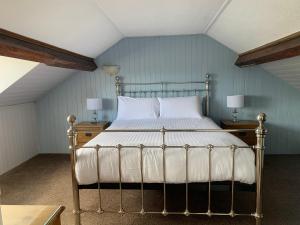 a bed in a room with two tables and two lamps at The Wylfa in Abersoch