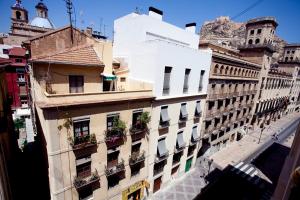 un antiguo edificio con plantas en los balcones de una calle en Apartamentos Alicante Centro by Renthas, en Alicante