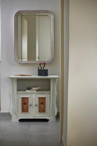 a white dressing table with a mirror on a wall at Alpha House Gialia in Andros