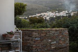 a stone wall with a view of a city at Alpha House Gialia in Andros