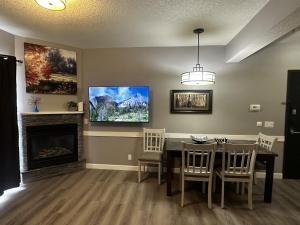 a dining room with a table and a fireplace at Luxury Two Queen Beds Condo - Grande Rockies Resort Indoor Parking Pool Hot tub GYM in Canmore