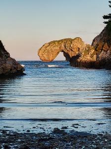 un arco en el agua cerca de una playa en Hotel Hontoria, en Hontoria