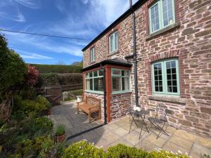 a brick house with a patio in front of it at Church Hill Cottage in Tavistock