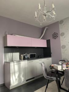 a kitchen with a microwave and a table with chairs at Apartment SAMANTA- self-checkin - near Jurmala, airport in Piņķi
