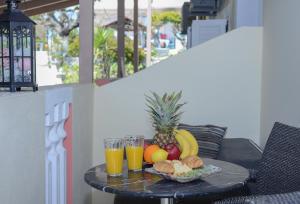 een tafel met een fruitschaal en twee glazen sinaasappelsap bij Zefiros by sea in Laganas