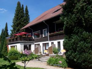 ein schwarzweißes Haus mit einem Balkon in der Unterkunft Mein Vierjahreszeiten Hotel Garni Superior in Sankt Andreasberg