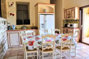 uma cozinha com mesa e cadeiras num quarto em Gites le mas clémentine Le Coquelicot em Saint-Julien-du-Serre