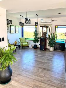 a living room with potted plants on the floor at Valle Las Piedras in Arroyo de Los Patos