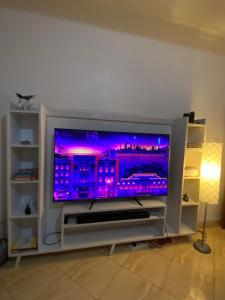 una TV a schermo piatto seduta su un centro di intrattenimento di J&R - Lovely two bedroom apartment in Jinja. a Jinja