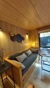 a bed in a room with a wooden wall at Hermoso departamento 2 ambientes con amplio jardin en el centro de SMA. 6V5 in San Martín de los Andes