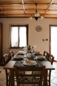 a dining room table with chairs and a wooden ceiling at Haisle im Untrborkh in Sauris