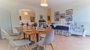 a dining room with a wooden table and white chairs at Giada Palace - Pool & Resort in Lucca