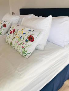 duas almofadas brancas com flores numa cama em Blå Dörren em Torekov