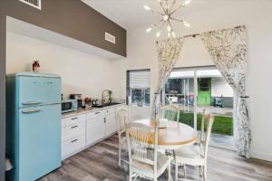 a kitchen with a table and a blue refrigerator at The Gregory: 2 Bed/1 Bath Guesthouse in Phoenix