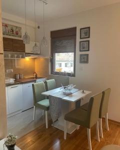 a kitchen with a table and chairs in a room at Apartman AS in Zlatibor