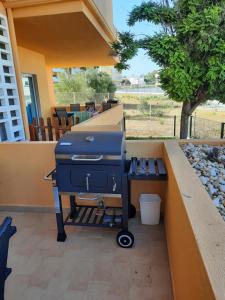 um grelhador sentado num pátio com uma mesa em Sunshine Apartment em Tavira
