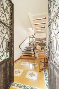 una puerta abierta que da a un pasillo con una escalera de caracol en Palazzo Candida B&B, en Gerace