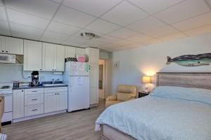 a bedroom with a bed and a kitchen with a refrigerator at Atlantic Beach Studio with Community Pool! in Atlantic Beach