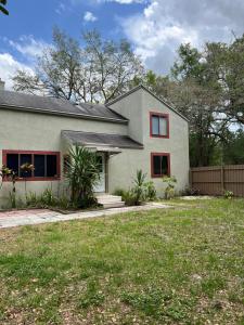 ein weißes Haus mit roten Fenstern und einem Hof in der Unterkunft Spacious and relaxing Home - Longwood, Florida in Orlando