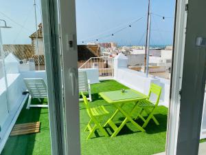 una mesa y sillas en el balcón de una casa en Ático Cádiz 360 en Cádiz