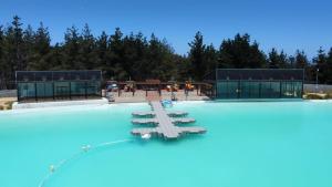 a swimming pool with blue water and two buildings at Laguna mar in Las Cruces