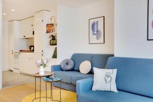 salon z niebieską kanapą i stołem w obiekcie CMG - Bastille / Le Marais - D w Paryżu